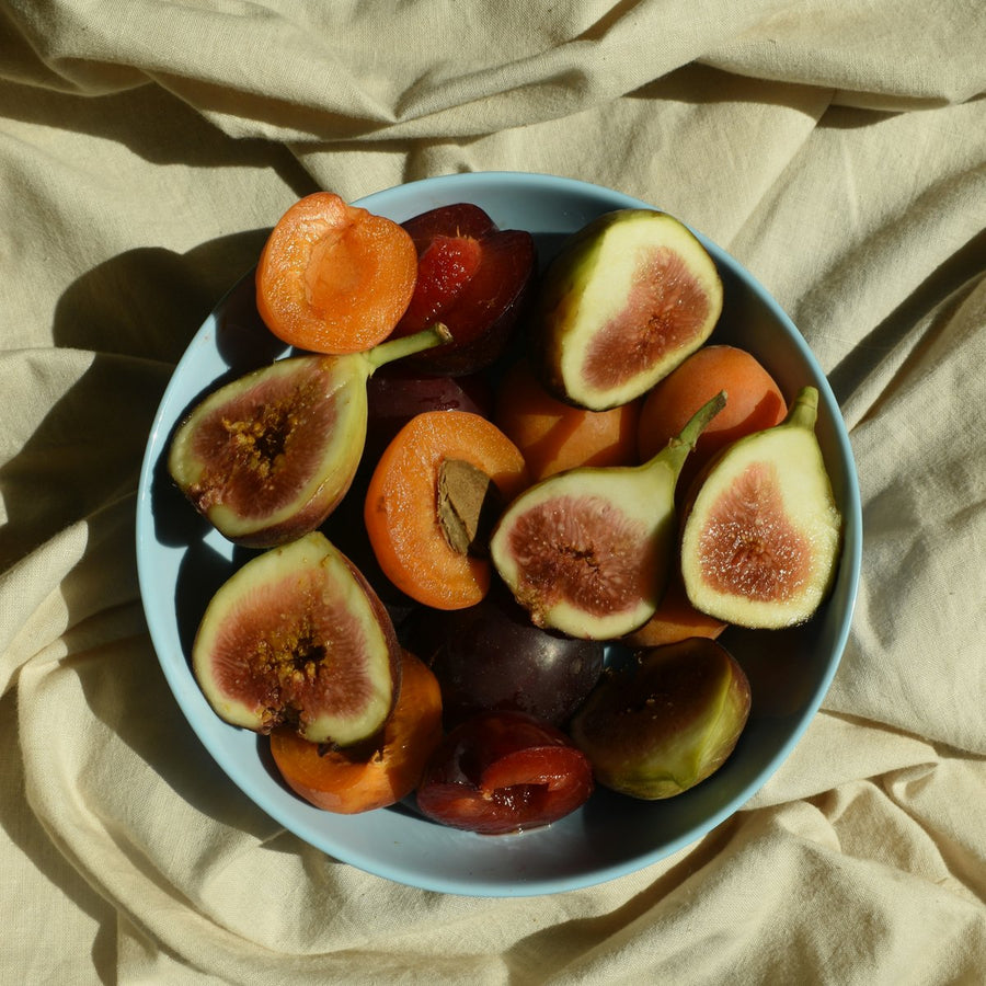 Bowl of fresh figs, apricots and cherries on natural linen, fruity fragrance family