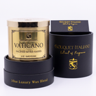 Vaticano Luxury Candle with its open black gift box on cream, studio still